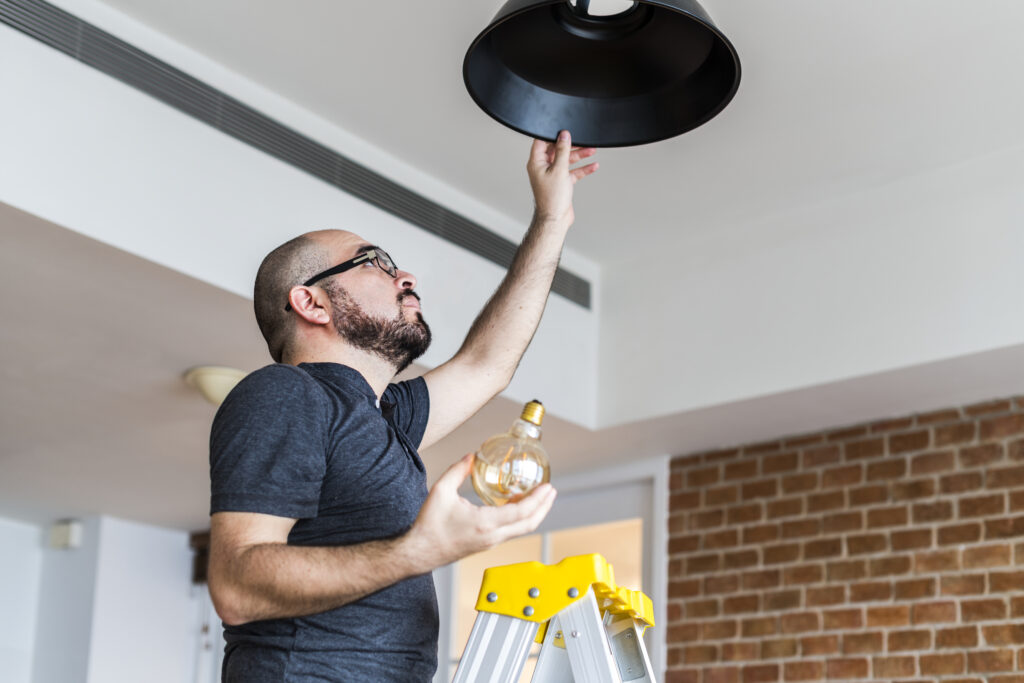 Light bulb replacement Dubai: man changing a light bulb