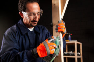 A handyman is sanding the piece of the wood