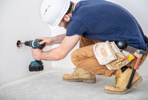 a handyman is working on an electrical outlet