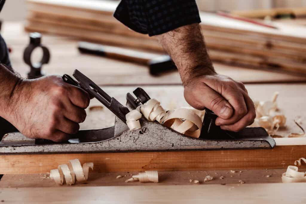 A Carpenter is making the custom shelf of wood