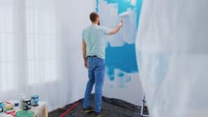A man is painting on the wall