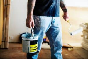 A man is taking the paint bucket to paint